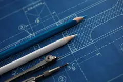 Drawing tools lying over blueprint paper close-up