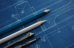 Drawing tools lying over blueprint paper close-up
