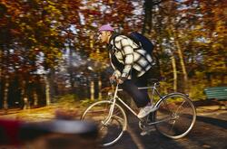 Cycling man, autumn trees on the background.