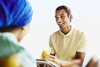 Waiter serving a drink to a woman.