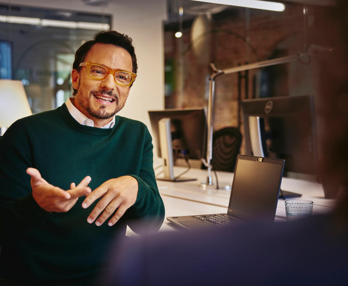A man smiling and in conversation