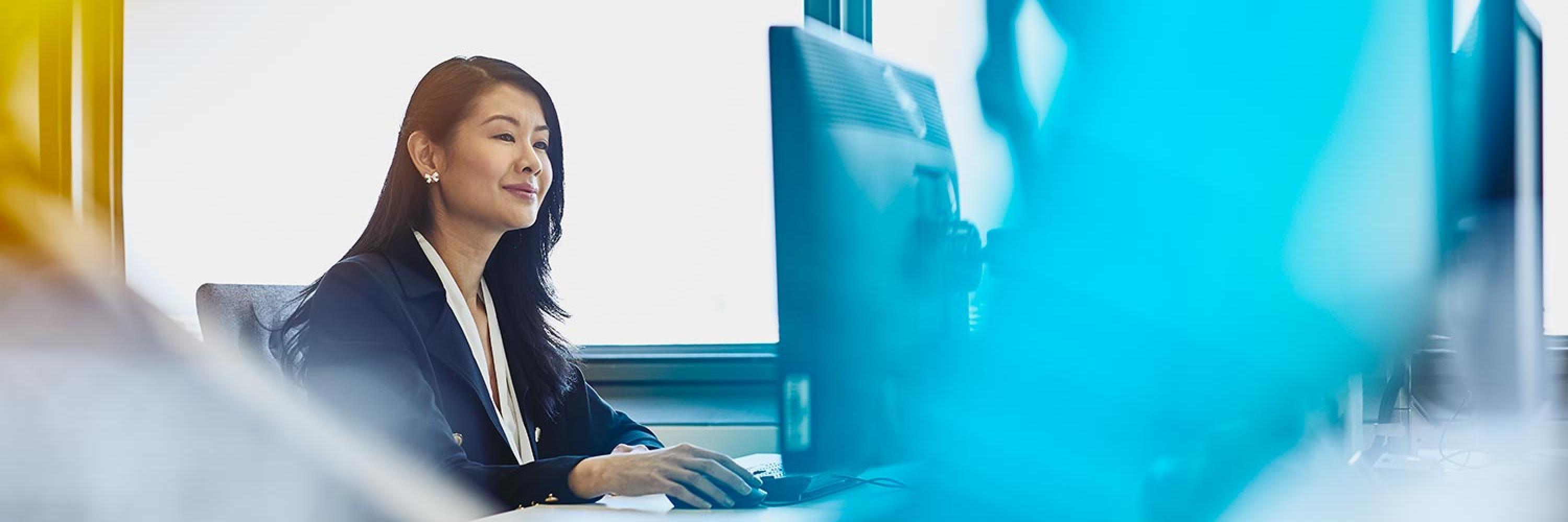 long haired woman looking at computer screen